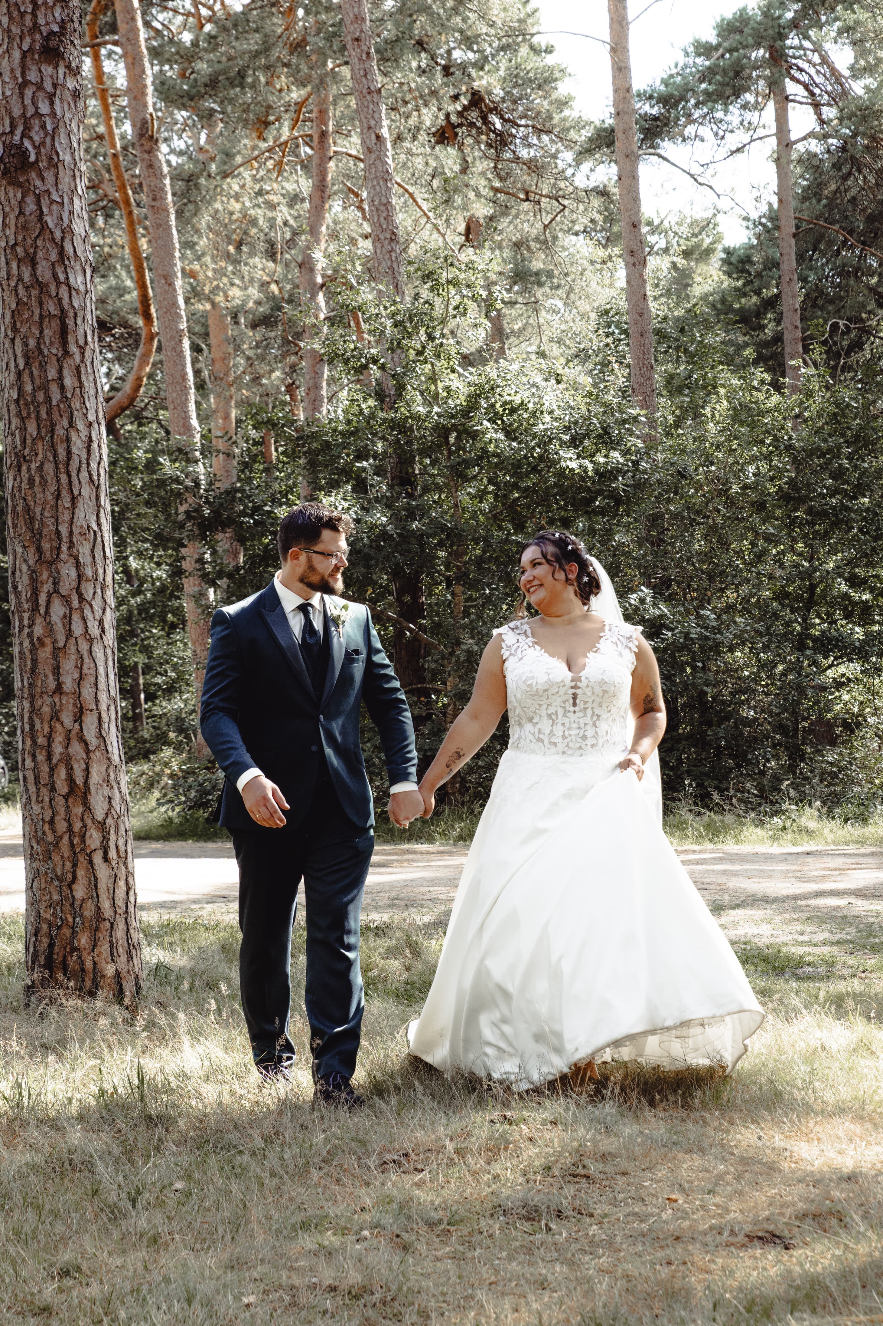 Pasgetrouwd stel loopt hand in hand door het bos
