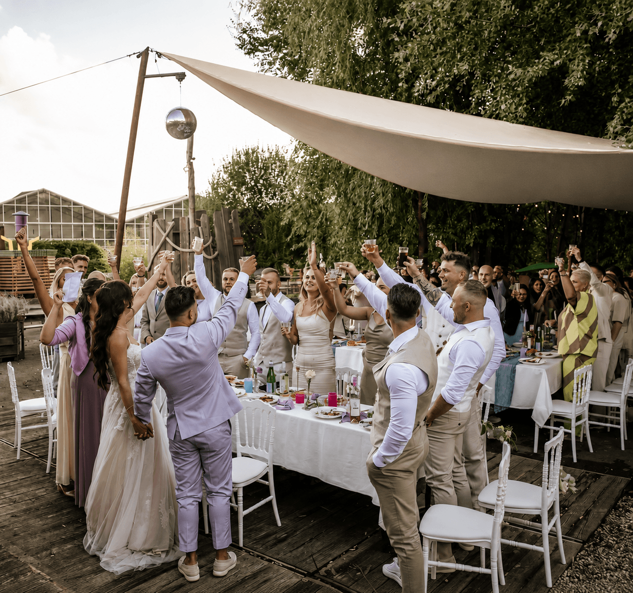 Bruiloftsgasten heffen hun glas tijdens een feest in de buitenlucht